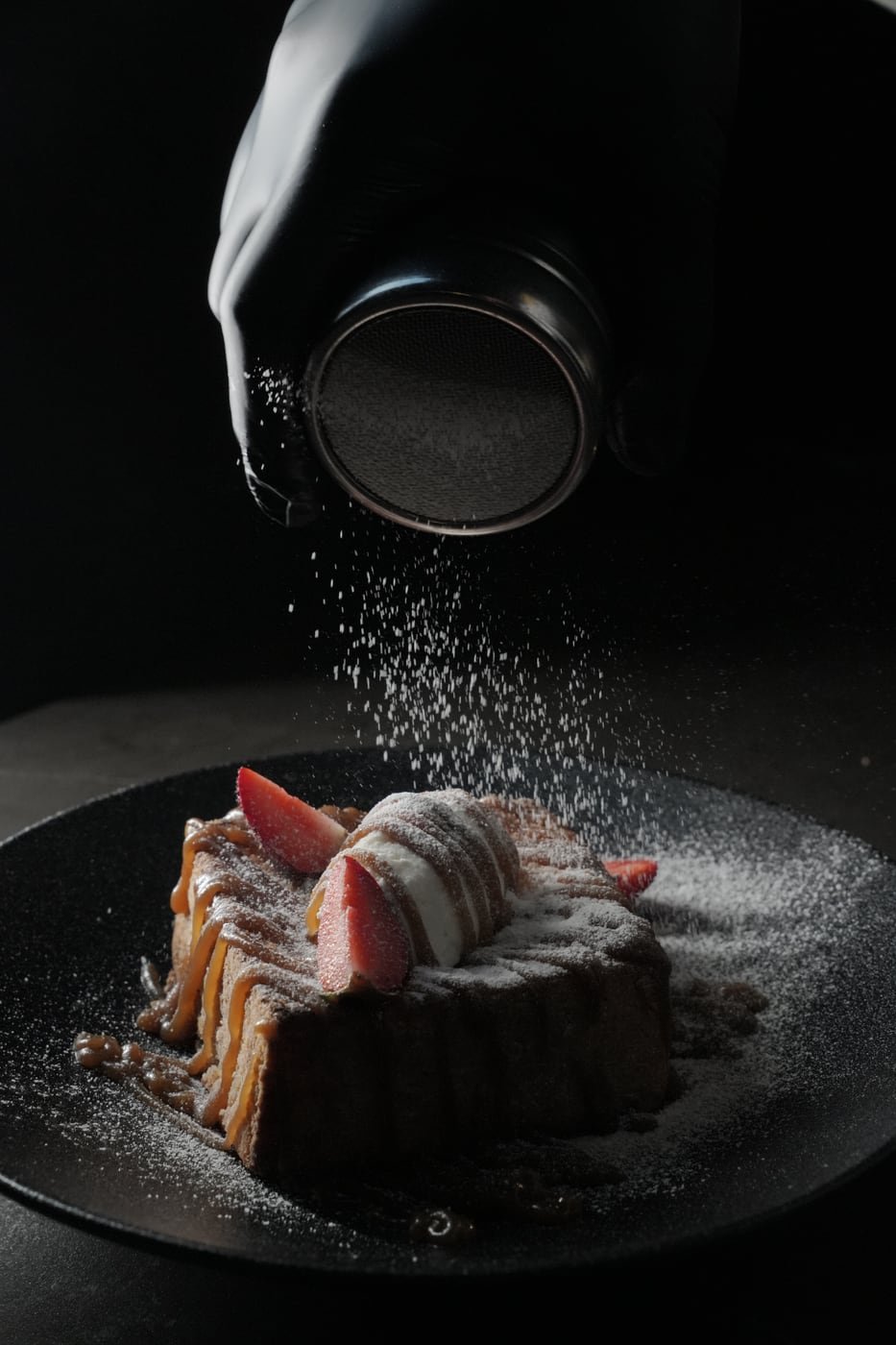 Dusting powdered sugar over French Toast Block