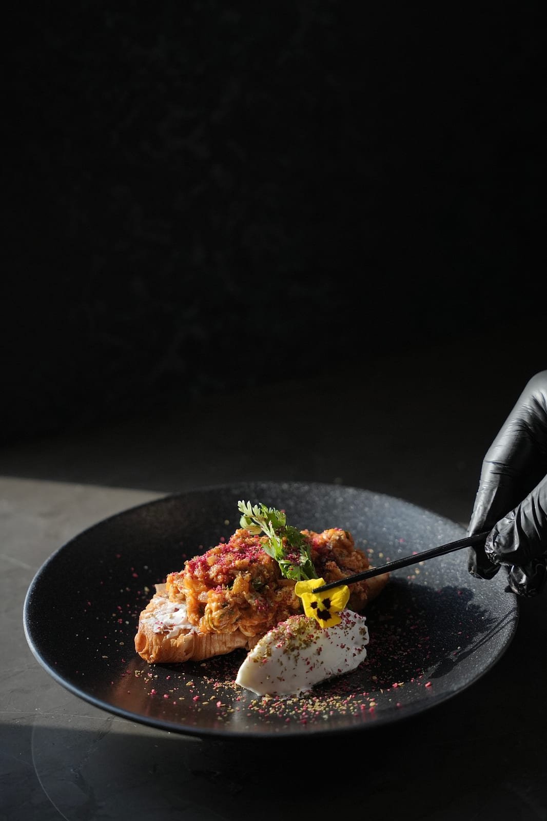 Chef plating a dish with tweezers