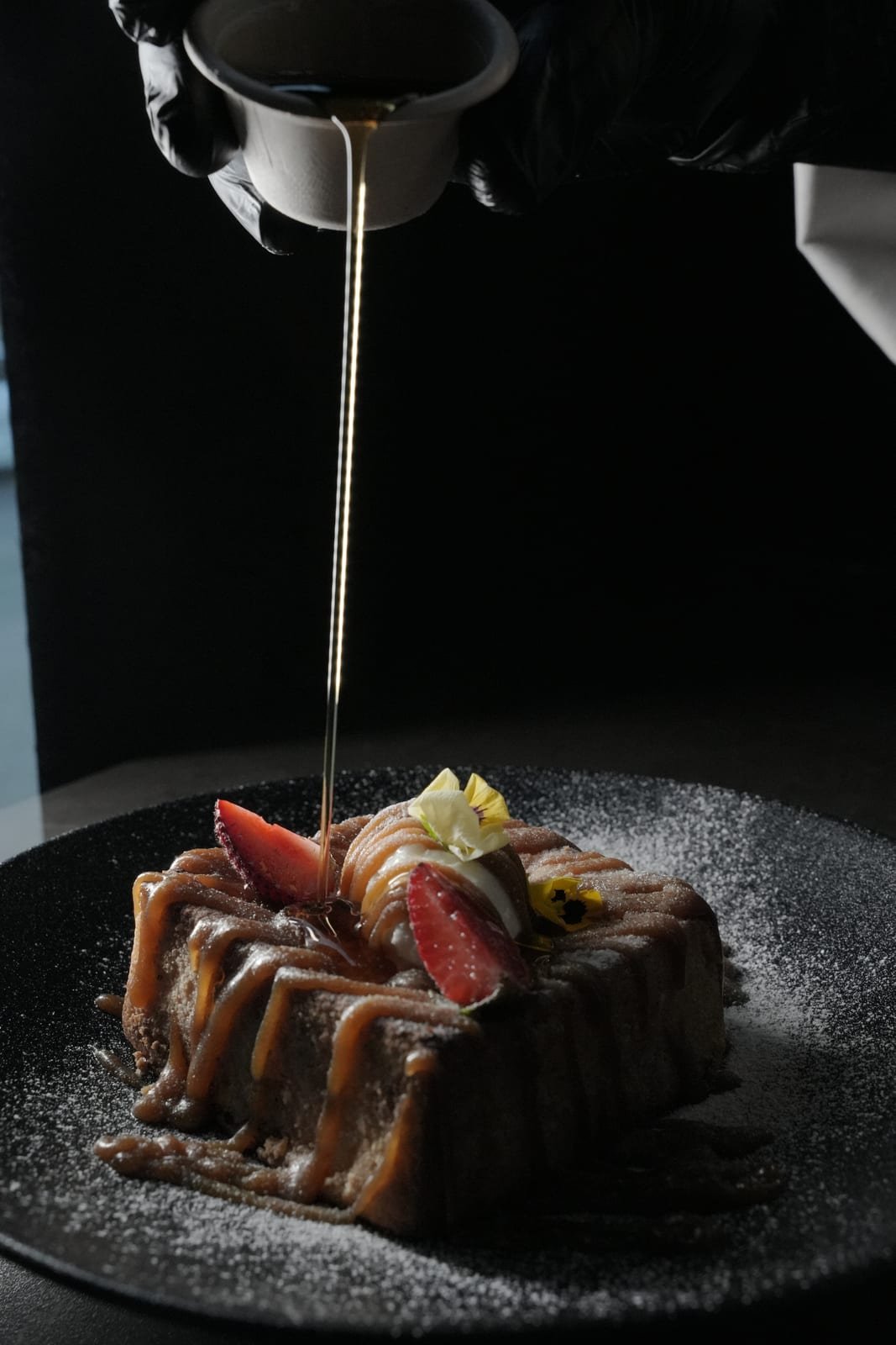Maple syrup being poured over French toast